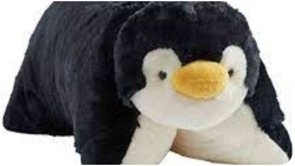 a stuffed penguin pillow laying down on a white background